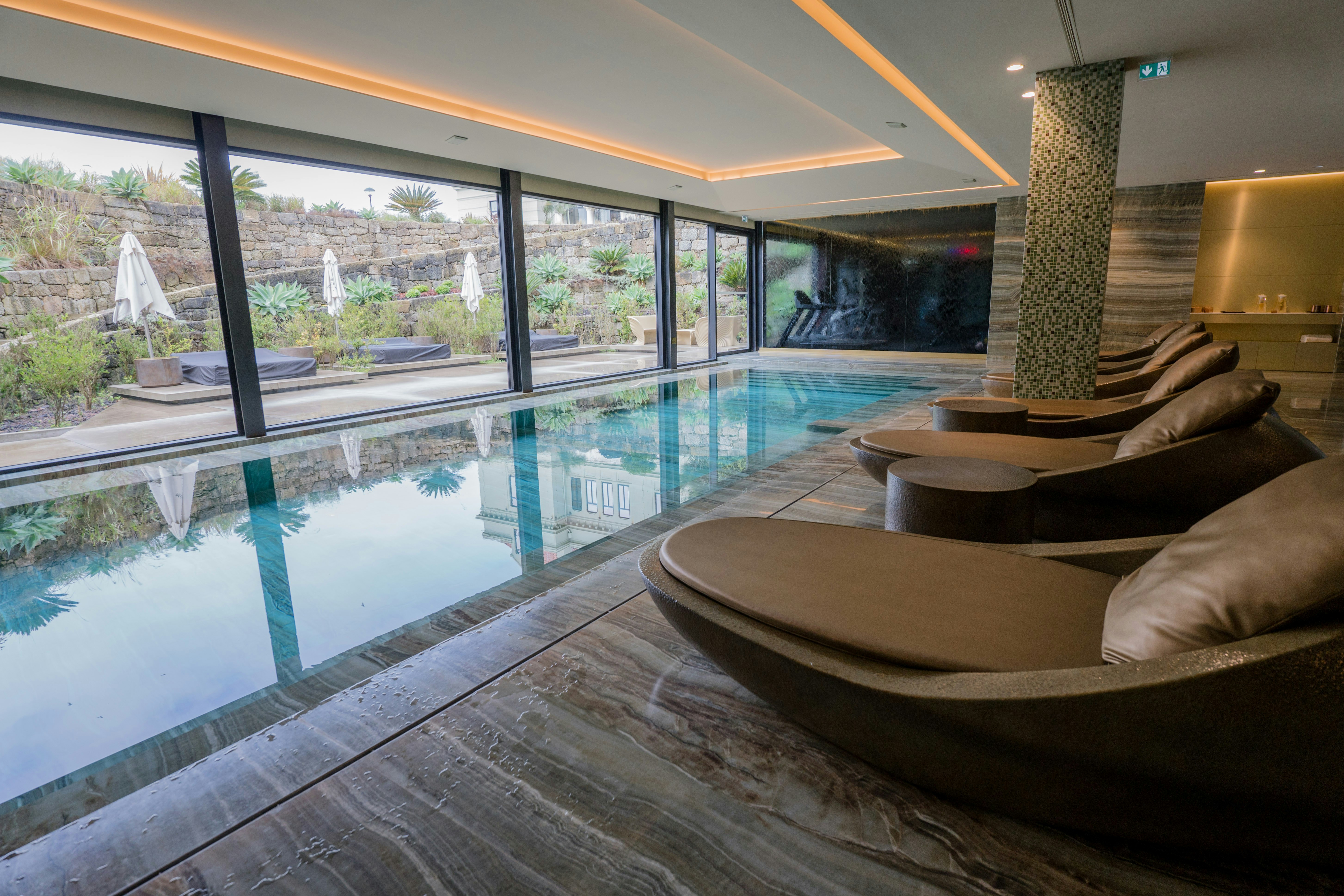 A large indoor swimming pool with lounge chairs